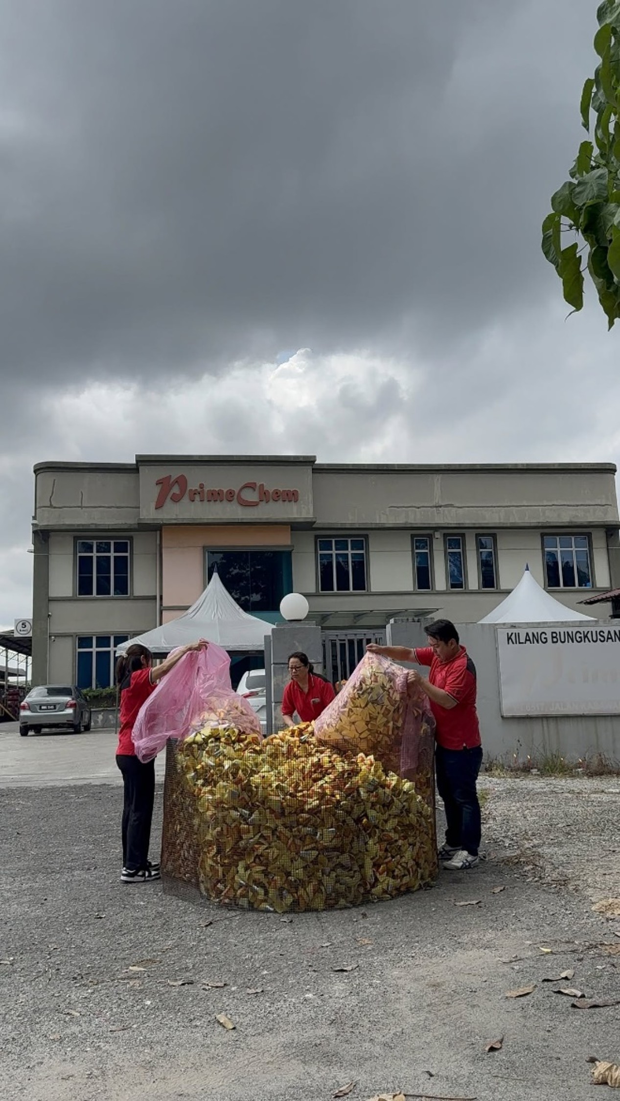 Employees sorting and handling bags of joss paper outdoors near the PrimeChem facility.