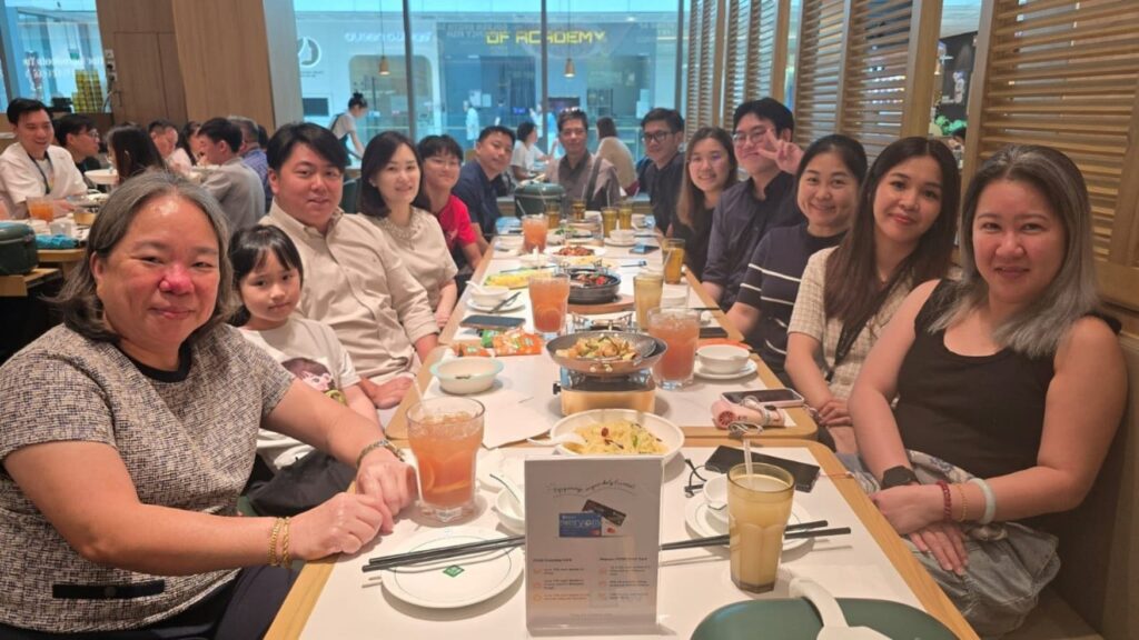 Group of colleagues enjoying a Christmas team lunch together at a restaurant table.