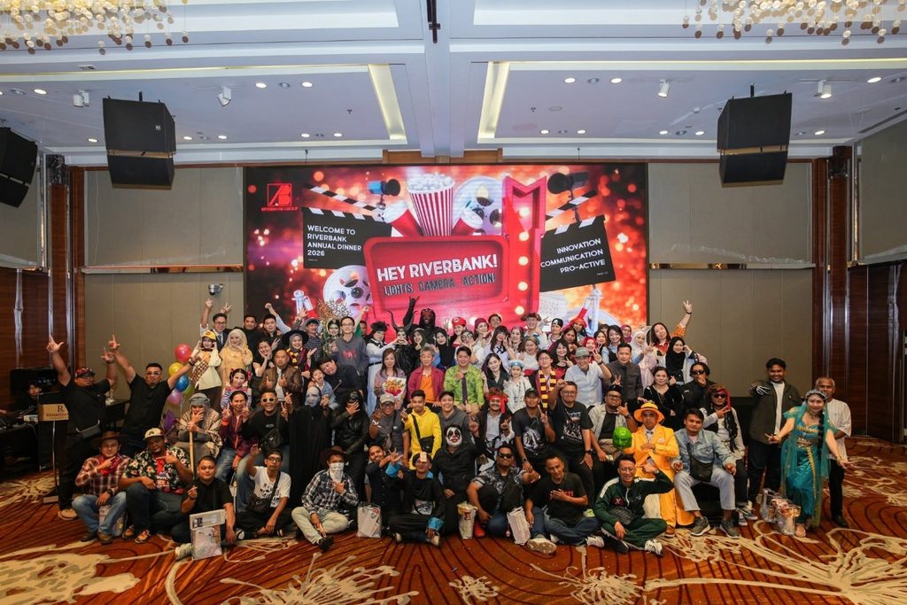 Group photo of employees in movie-themed costumes on stage during the Riverbank Annual Dinner 2026.